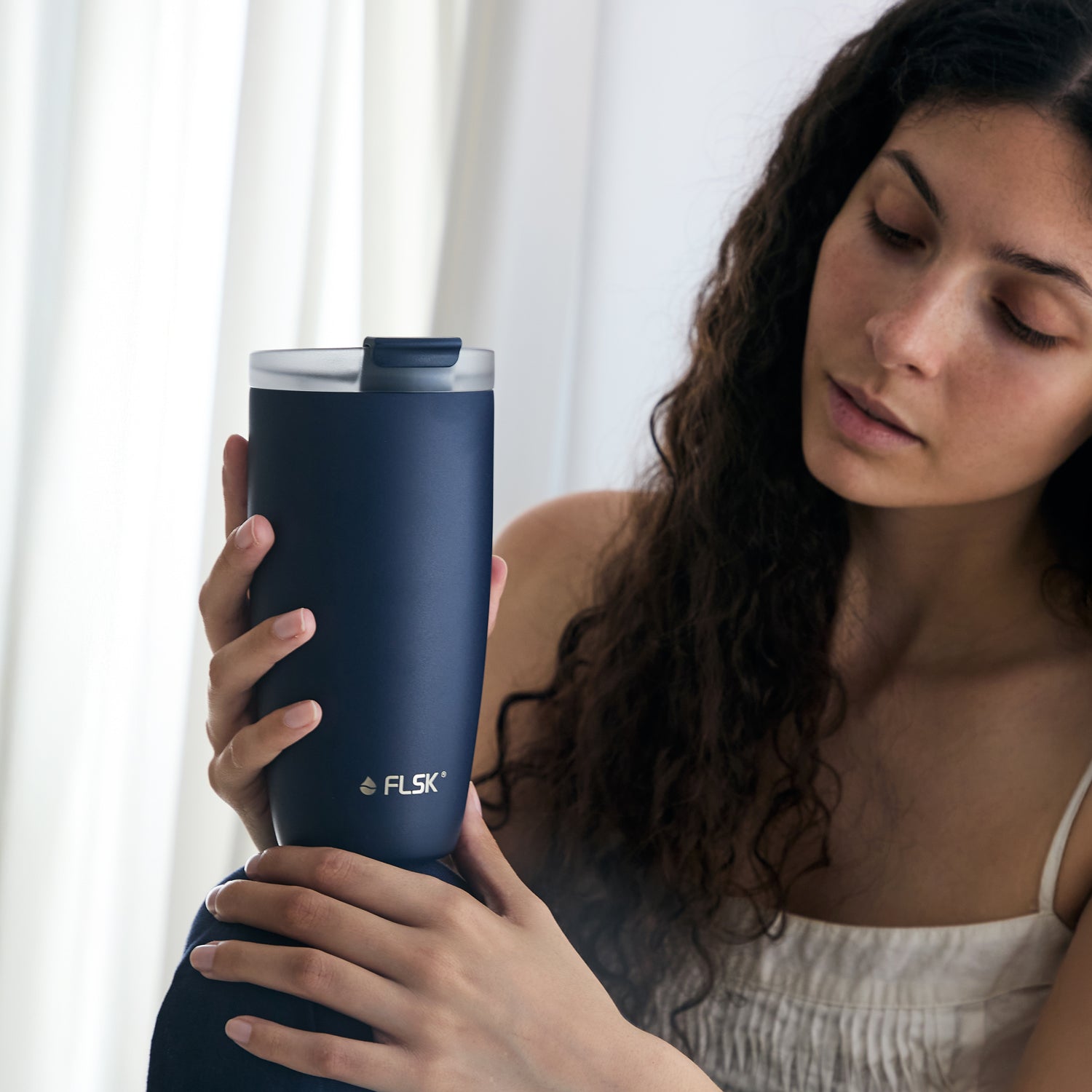 Frau präsentiert FLSK Kaffeebecher 500 ml